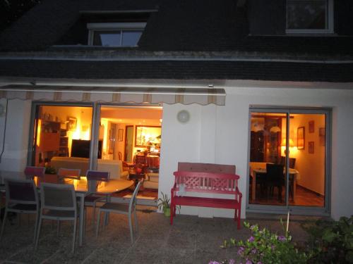 - une table à manger et des chaises sur la terrasse la nuit dans l'établissement La Vie Au Roze, à Quéven