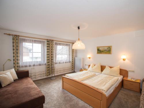 a bedroom with a large bed and a couch at Appartementhaus Renate in Rauris
