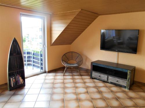een woonkamer met een flatscreen-tv en een stoel bij Cologne Homestay in Keulen