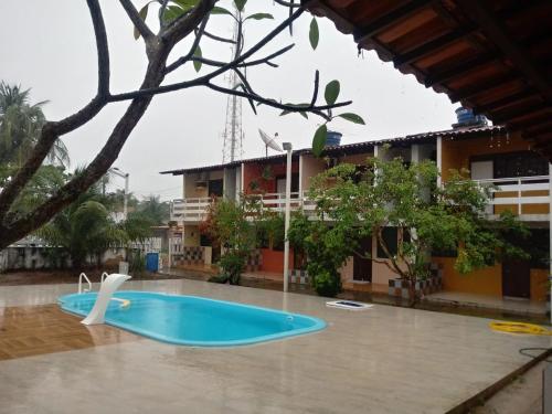 a swimming pool in front of a building at Chalés Praia do Frances in Praia do Frances