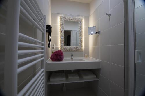 a bathroom with a sink and a mirror at Hôtel de la Tabletterie in Méru