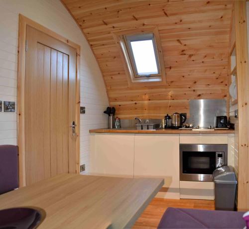 a kitchen with a table and a window in a room at Seaview Pod and hot tub in Ballachulish