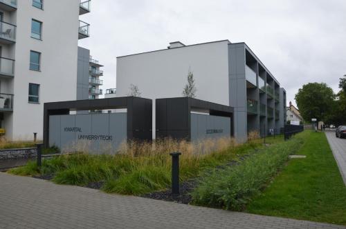 a building in a city with a grass field at Apartament z Ogrodem Gdansk Przymorze in Gdańsk