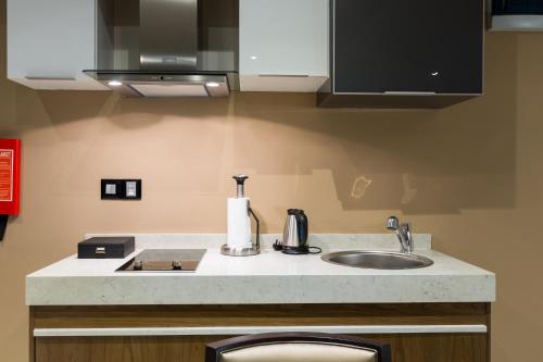 a kitchen with a sink and a counter top at The Palms by Eagles in Takoradi
