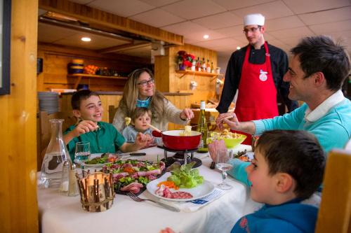 un groupe de personnes assises autour d'une table en train de manger dans l'établissement VTF Les Econtres, à Chamonix-Mont-Blanc