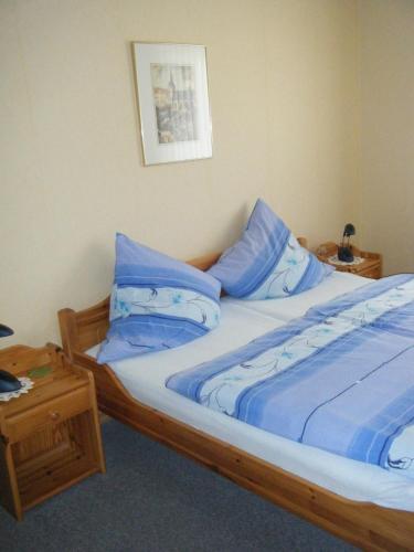 a bed with blue sheets and blue pillows on it at Ferienweingut Hensler in Briedel