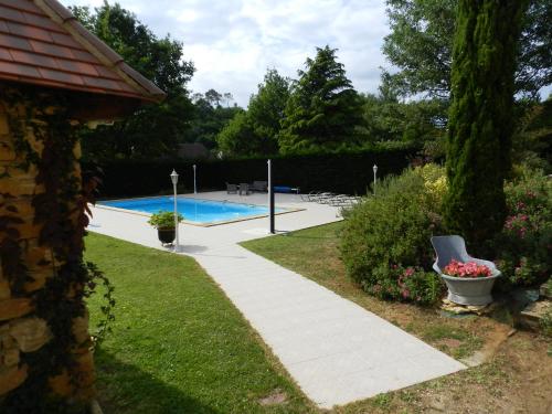 un jardin avec une piscine et une maison dans l'établissement La Sembelie, à Carsac-Aillac