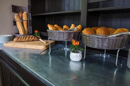 two baskets of bread sitting on a counter with at Hôtel de la Tabletterie in Méru