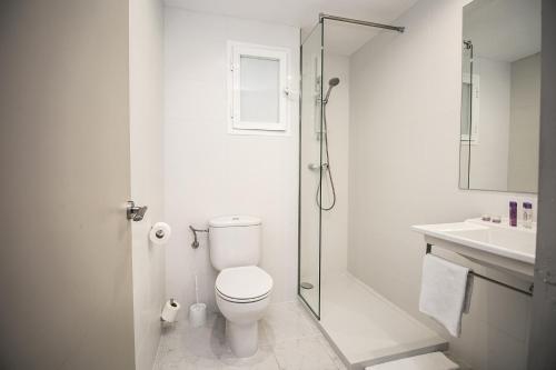 a white bathroom with a toilet and a shower at The Purple Hotel - Adults Only in San Antonio