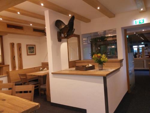 a restaurant with a counter with a butterfly on the wall at Berghaus Koglmoos in Auffach