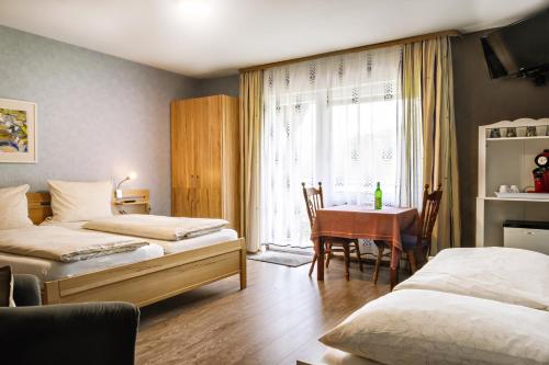 埃倫茲–波爾特斯多夫的住宿－施耐德費瑞恩葡萄酒莊，客房设有两张床、一张桌子和一扇窗户。