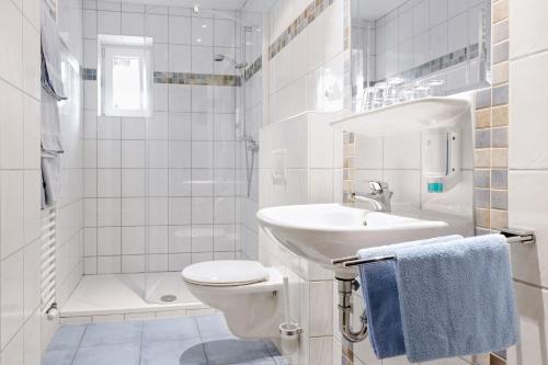 a white bathroom with a toilet and a sink at Ferien Weingut Schneider in Ellenz-Poltersdorf