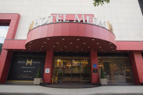 فندق ميباس في موستار: متجر أمام مبنى وردي مع وضع علامة عليه