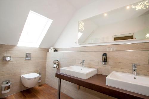 a bathroom with two sinks and a toilet at Hotel Alt Westerholt in Herten