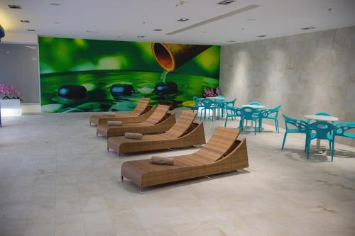 a room with chairs and tables and a large painting at Hotel Mepas in Mostar