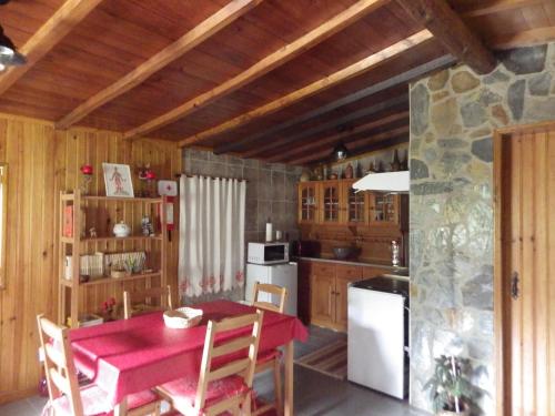cocina con mesa roja y nevera blanca en Casa da Eira en Cerdeira