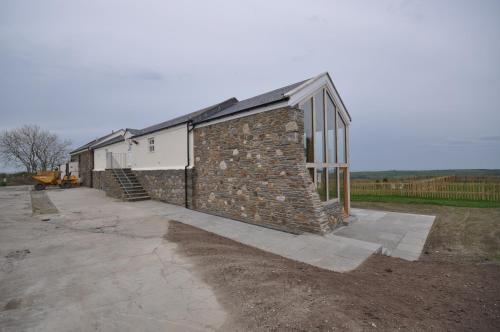 a brick building with a stone wall at The Barn at Ballaloaghtan in Ballasalla