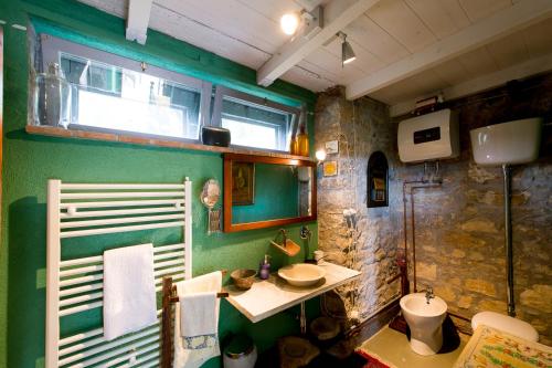 uma casa de banho verde com um lavatório e um WC em La Limonaia em San Venanzo