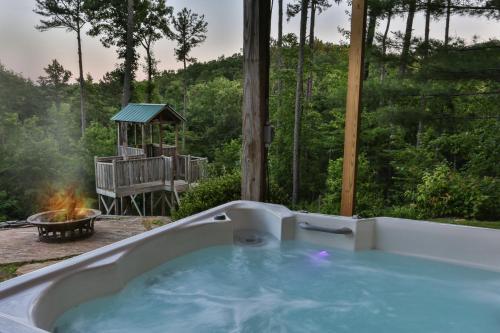 a hot tub in a backyard with a fire pit at Heaven's Gate in Ellijay