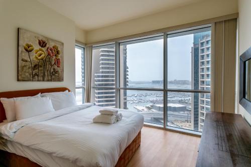 a bedroom with a large bed and a large window at One Perfect Stay - Marina Terrace in Dubai