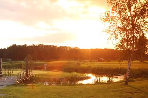 a view of a golf course with a pond at Golfpark Strelasund in Süderholz