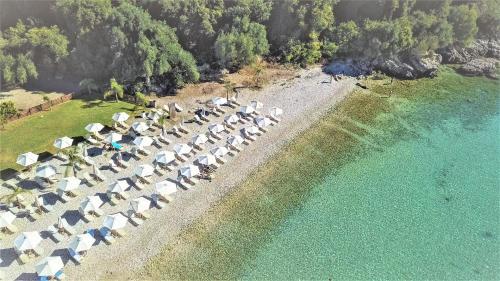 an aerial view of a beach with chairs and umbrellas at Corfu Aqua Nisaki in Nisakion