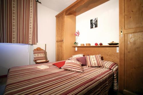 a bedroom with a bed with a red laptop on it at Lagrange Vacances Le Domaine des 100 Lacs in Cauterets