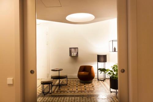 a hallway with a chair and a table at DestinationBCN - Universitat Rooms in Barcelona