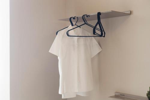 a white shirt is hanging on a wall at DestinationBCN - Universitat Rooms in Barcelona