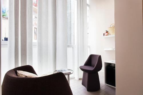 a living room with two chairs and a window at DestinationBCN - Universitat Rooms in Barcelona