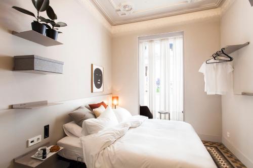 a bedroom with a bed with white sheets and pillows at DestinationBCN - Universitat Rooms in Barcelona