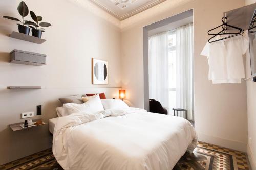 a bedroom with a white bed and a window at DestinationBCN - Universitat Rooms in Barcelona