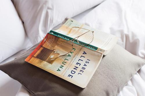 a book with glasses sitting on top of a bed at DestinationBCN - Universitat Rooms in Barcelona