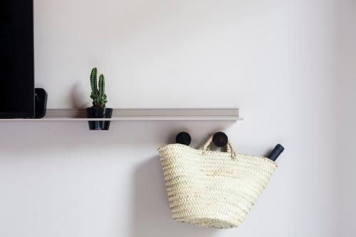 a basket hanging on a wall with a shelf at DestinationBCN - Universitat Rooms in Barcelona