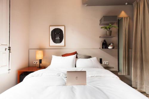 a bedroom with a bed with a laptop on it at DestinationBCN - Universitat Rooms in Barcelona