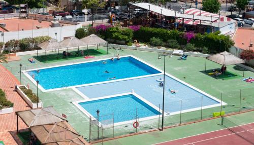 a pool with a tennis court and tennis racquet on top of it at Gemelos 2 - Beninter in Benidorm
