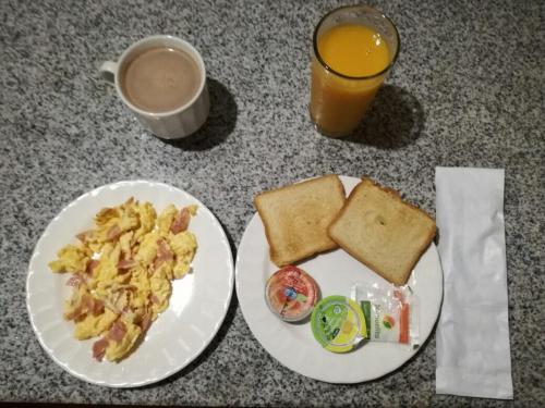 a table with a plate of breakfast food and a cup of coffee at Hotel Pizzeria Opera Tolú in Tolú