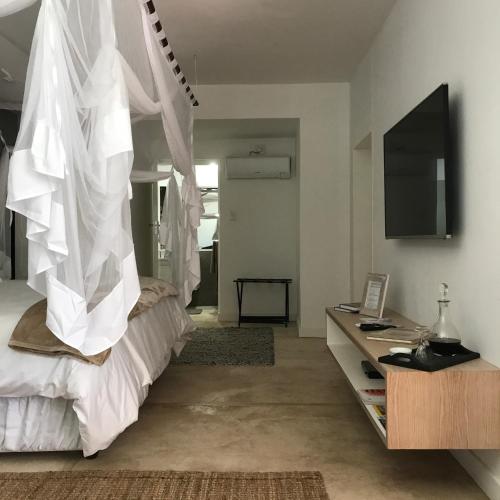 a bedroom with a bed with white drapes at Bryan's View in Windhoek