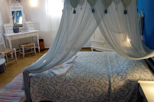 a bedroom with a bed with a canopy at Cretan Village Hotel in Agios Nikolaos