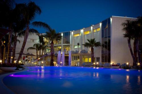 a large building with a swimming pool at night at DubaiVillage in Camposano