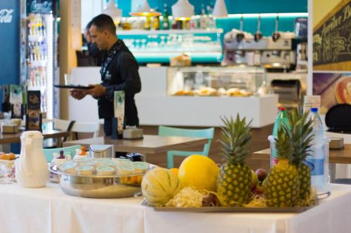 a man holding a tray of fruit on a table at DubaiVillage in Camposano