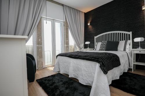 ポルトにあるM&M Space Apartments MM3の黒い壁のベッドルーム1室(白いベッド1台付)
