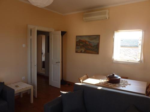 - un salon avec un canapé, une table et une fenêtre dans l'établissement Corfu Old Town Apartment, à Corfou