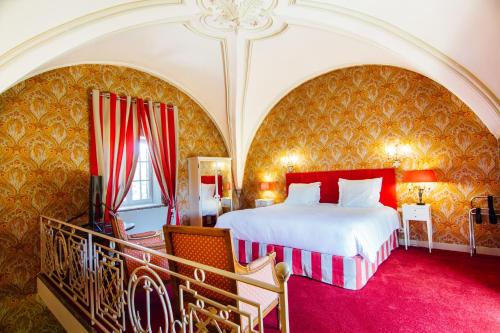 - une chambre avec un grand lit aux murs rouge et or dans l'établissement Château D'igé, à Igé