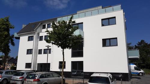 a white building with cars parked in a parking lot at Cloud 7 II in Heinsberg