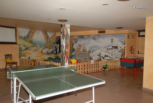 a ping pong table in a room with a mural at Hotel Baita Clementi in Bormio