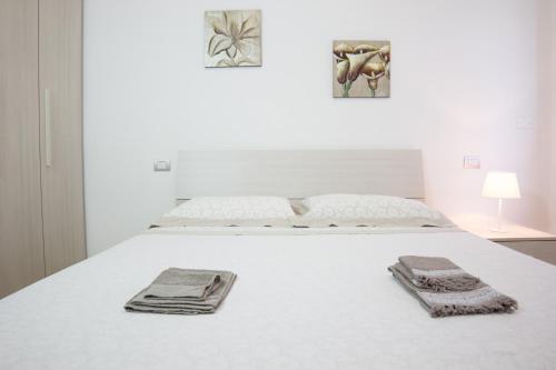 レッチェにあるPirandello Holidaysのベッドルーム1室(白いベッド1台、タオル付)