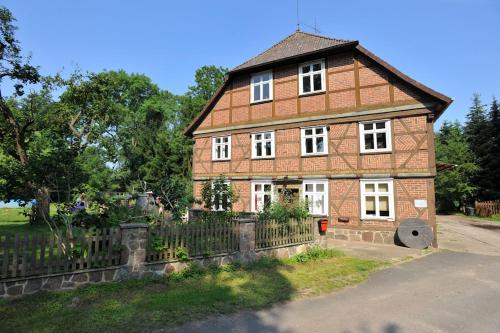 a large brick house with a fence in front of it at Beutower Muhle Ferienwohnung in Beutow