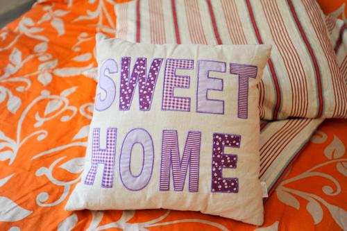 a pillow with the words sweet home sitting on a bed at Beutower Muhle Ferienwohnung in Beutow