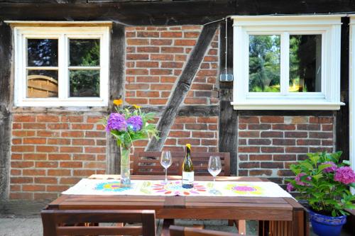 een houten tafel met twee wijnglazen en een bakstenen muur bij Beutower Muhle Ferienwohnung in Beutow
